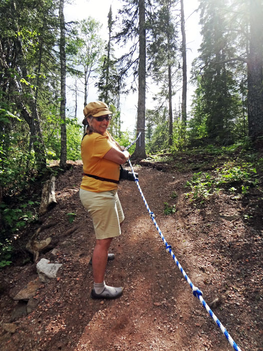 Karen Duquette using the rope to get up a steep hill